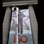 large banner outside between two columns showing male model and 150 years