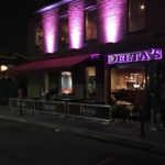 exterior of Delta's with sidewalk barrier with graphic and backlit sign