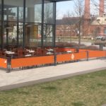 orange sidewalk barriers outside restaurant