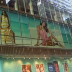 large window graphics of women in clothing in second floor store window on city street